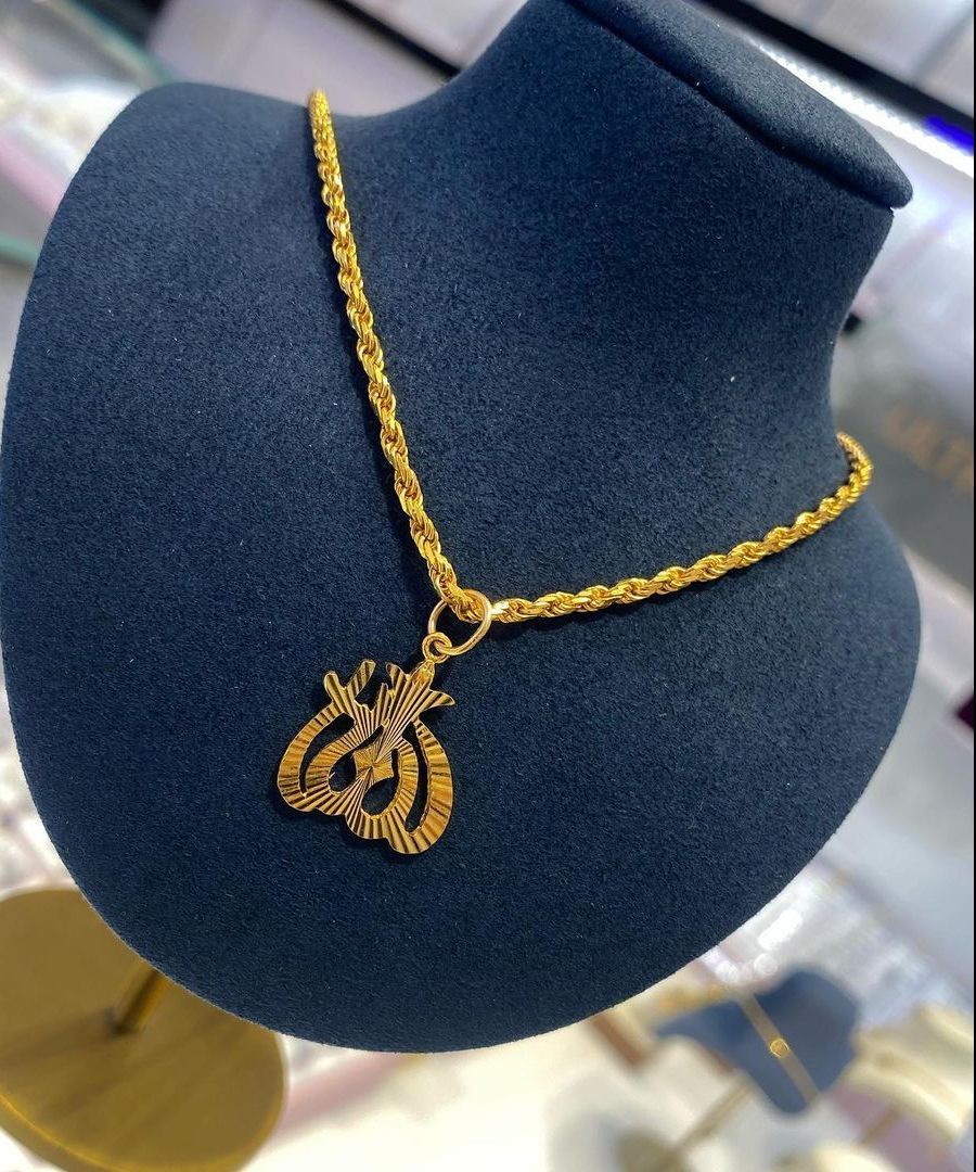 A gold coin necklace is displayed on a gold stand