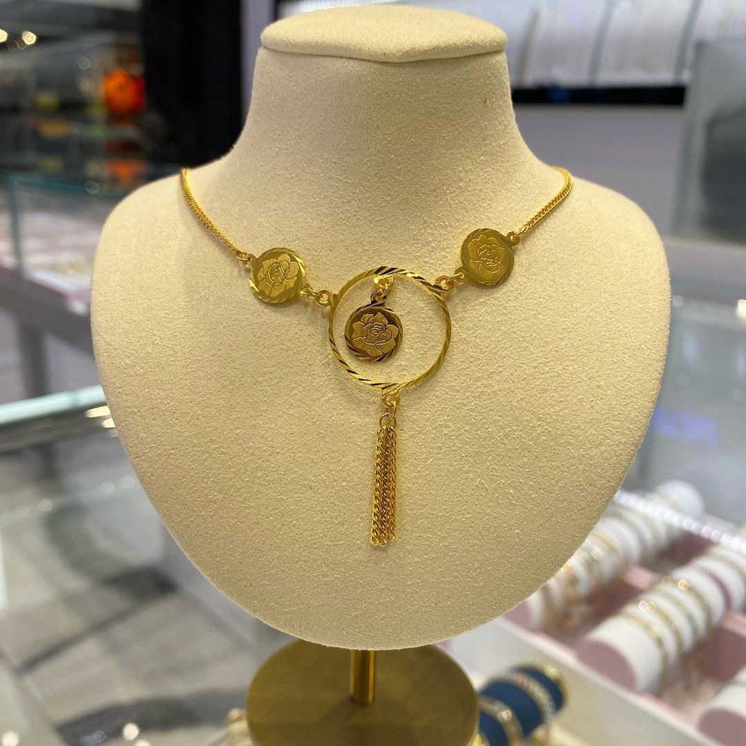 A gold necklace is on a mannequin in a store