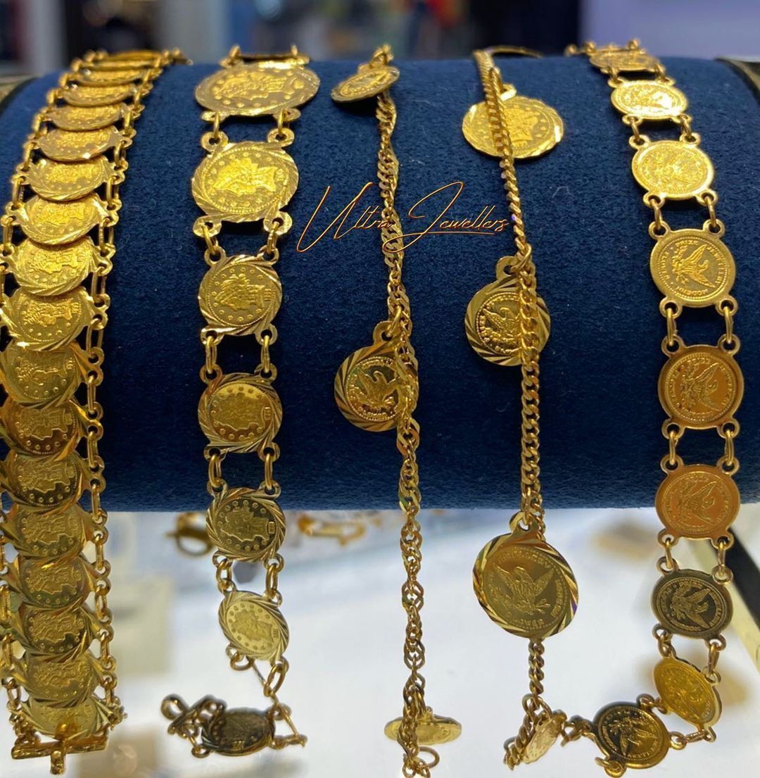 A bunch of gold bracelets with coins on them