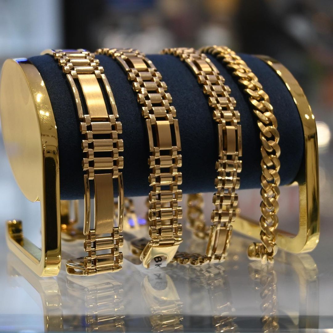 A display of gold bracelets on a blue cloth