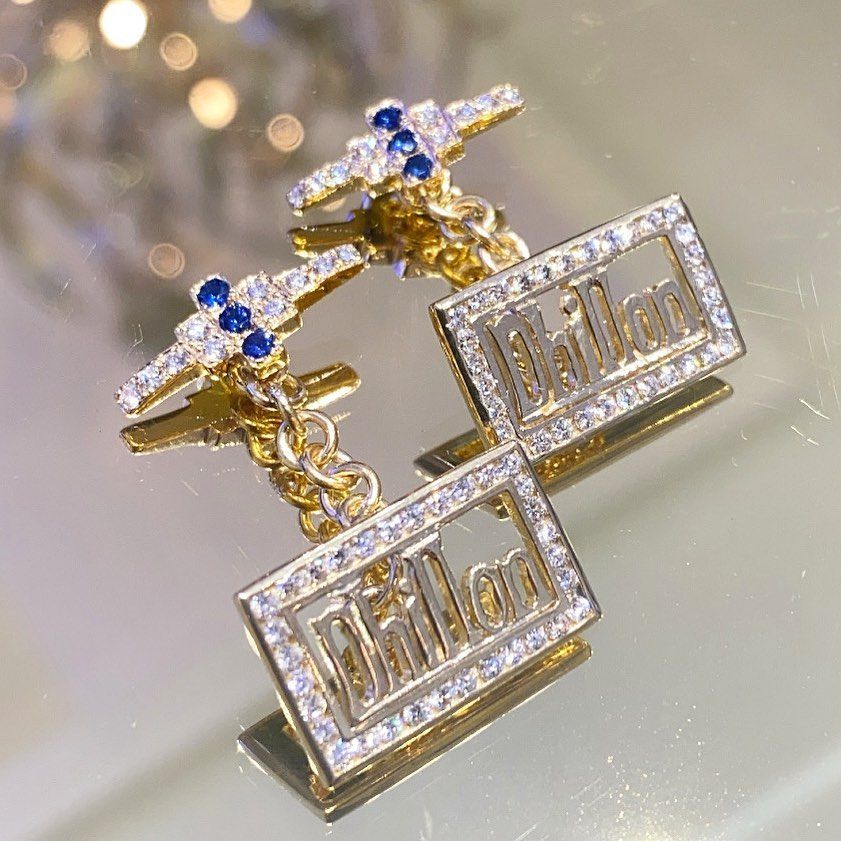 A pair of cufflinks with the word phillip on them