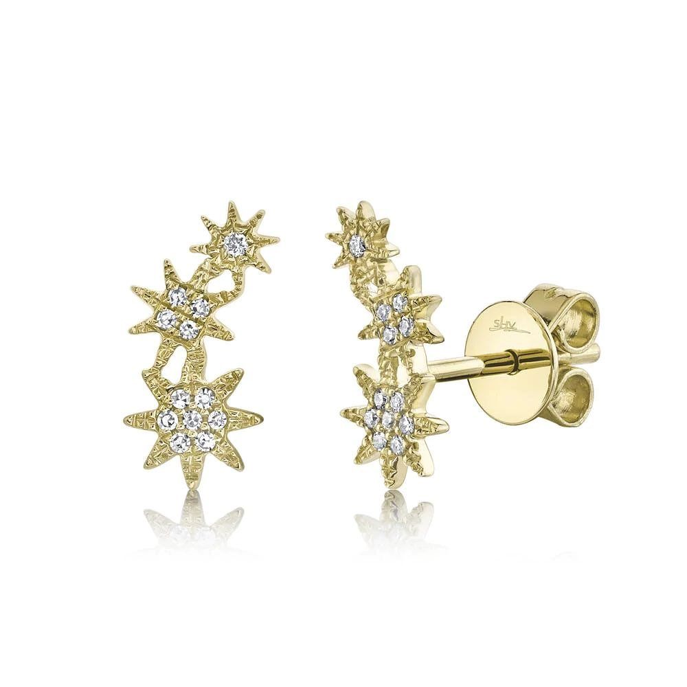 A pair of yellow gold star stud earrings with diamonds on a white background.
