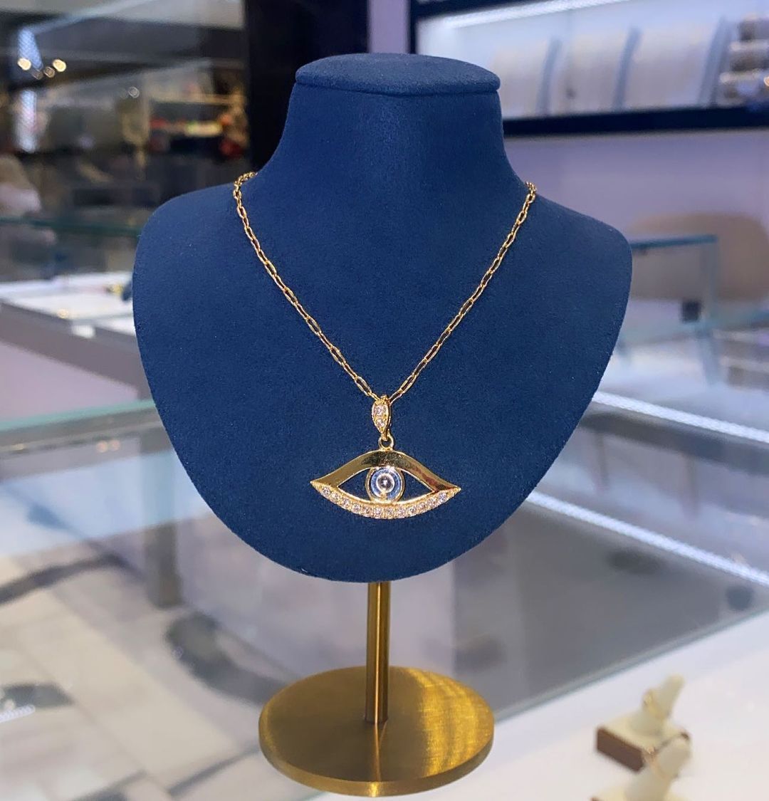 A blue mannequin with a gold necklace on it