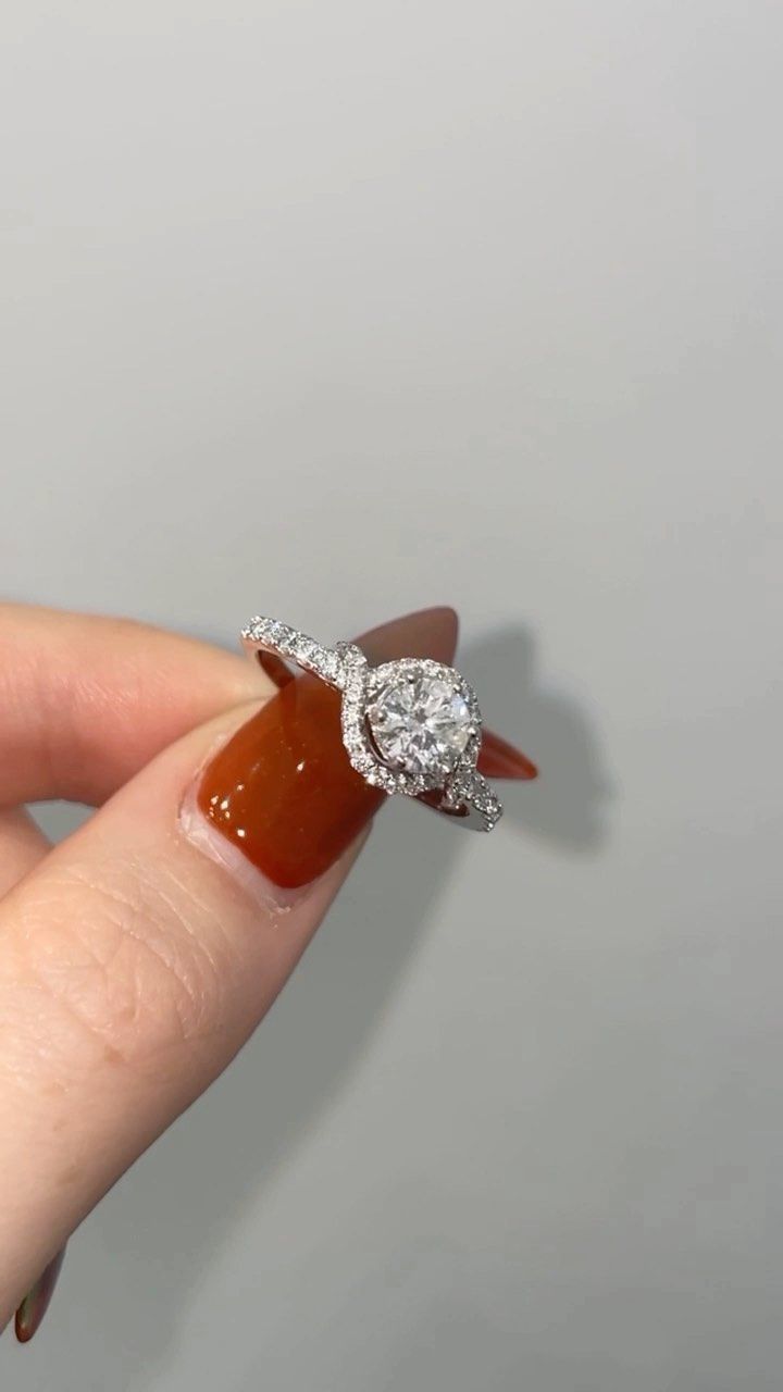 A person is holding a diamond ring in their hand.