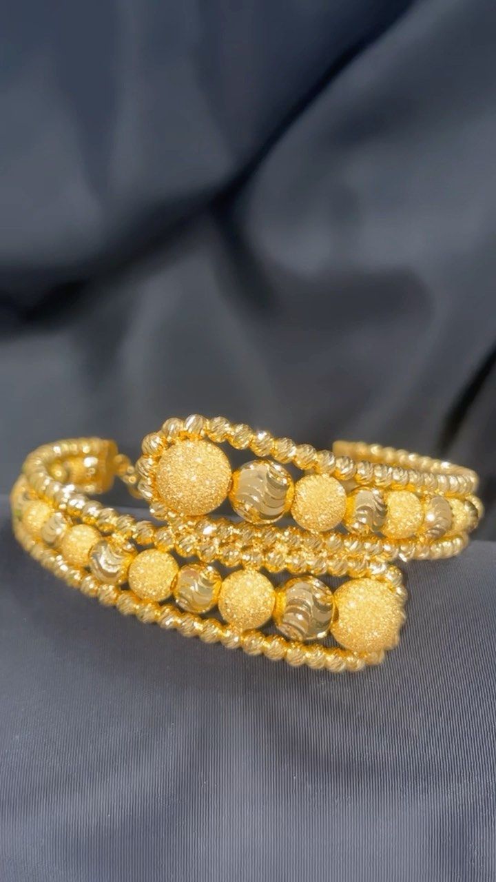 A close up of a gold bracelet on a cloth