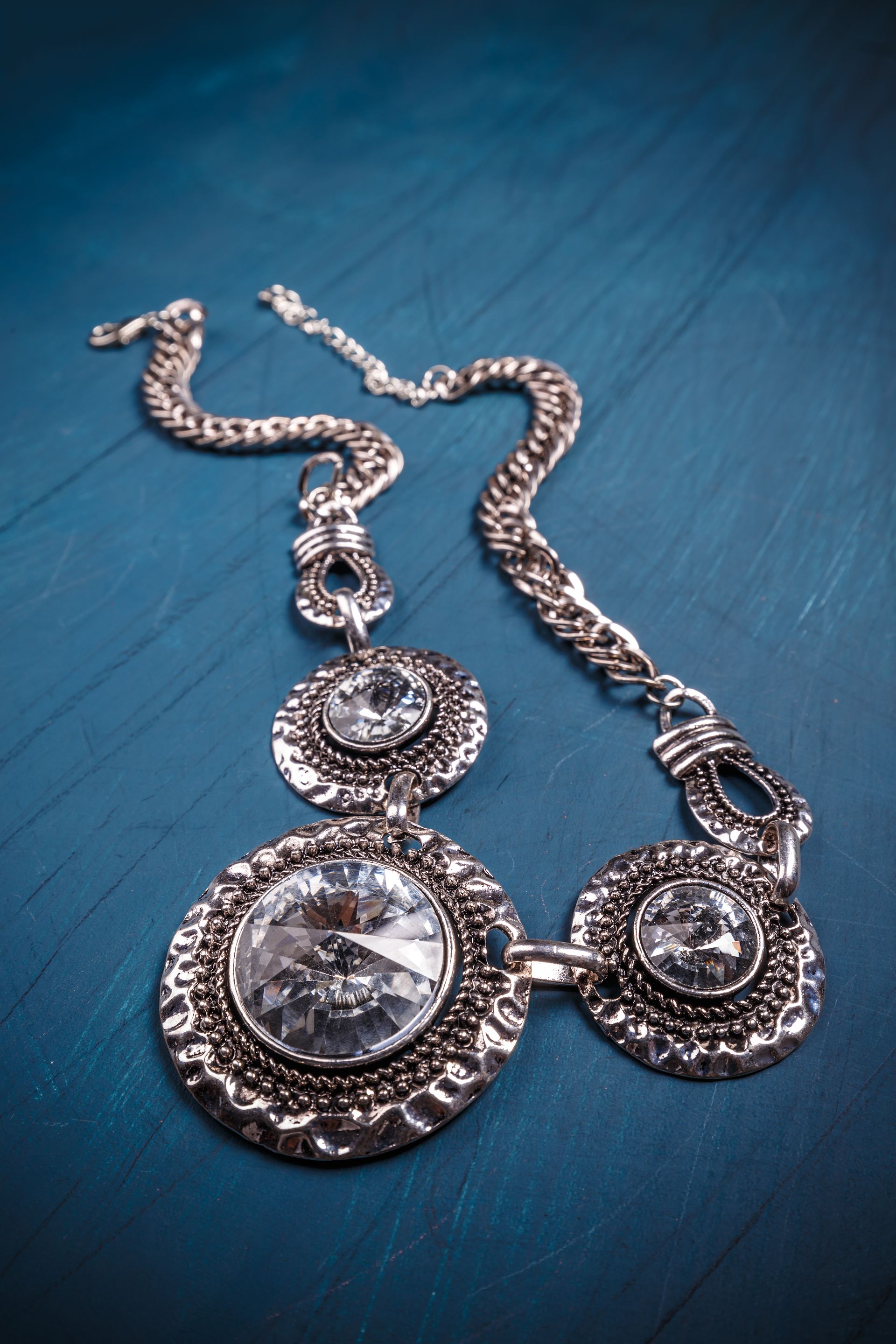 A close up of a necklace on a blue surface