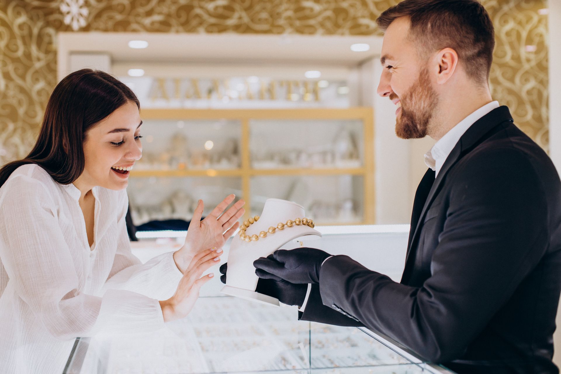 A man is giving a woman a necklace in a jewelry store.