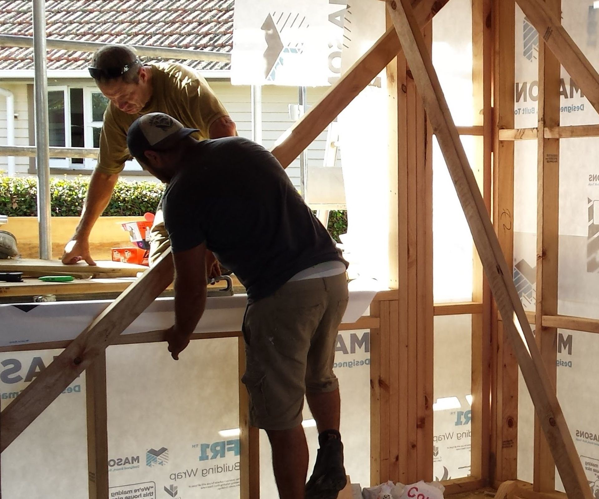 two builders talking with framing and background