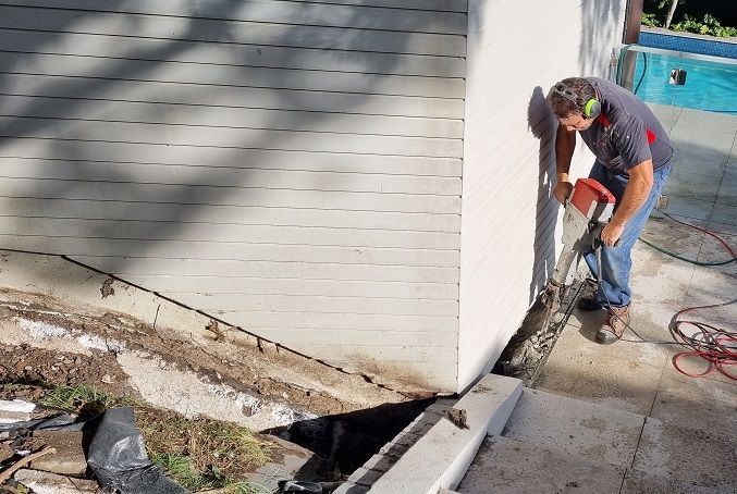 man using jackhammer by Swimming Pool