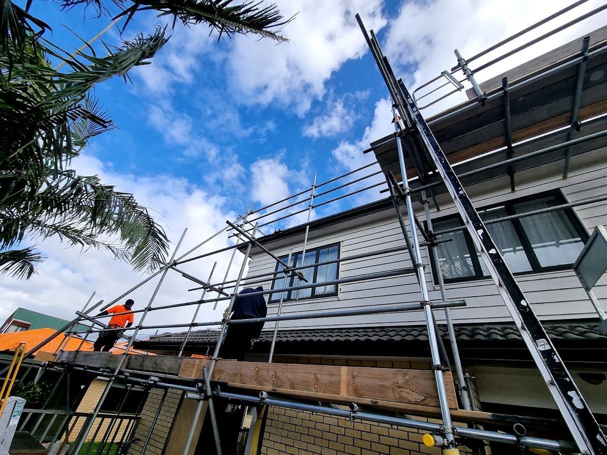 Scaffolding against a blue sky viewed through palm fronds