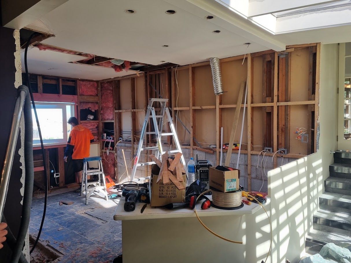 Room under renovation with exposed framing and a ladder