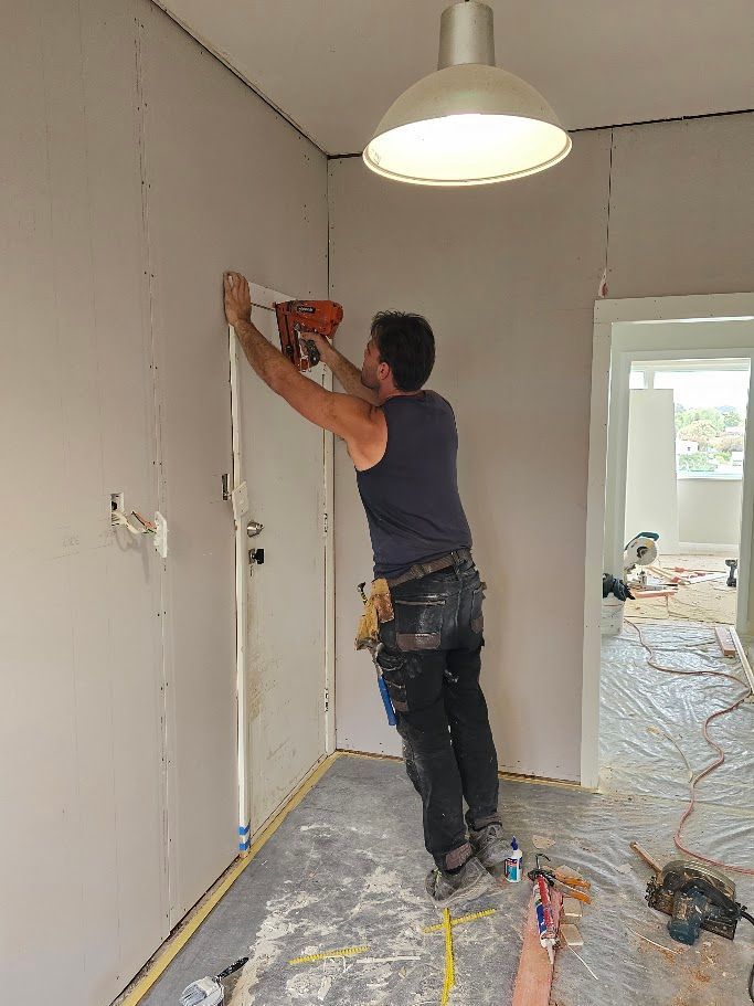 Man installing a pendant light fixture on the ceiling
