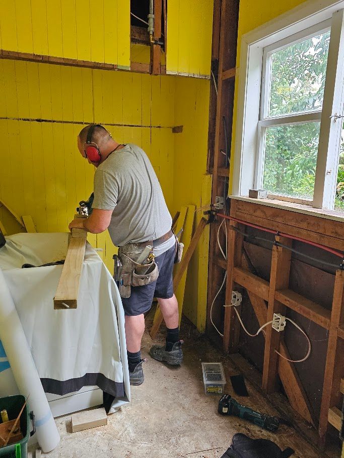 Man working in a room with yellow wall under renovation
