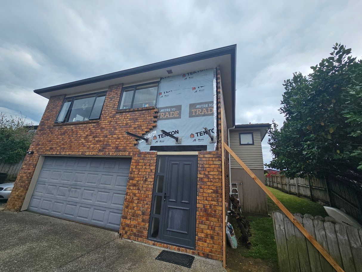 Brick house exterior with weatherproof wrap during renovation