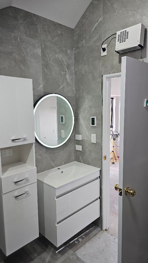 Dark stone-tiled bathroom with wall-mounted heater unit