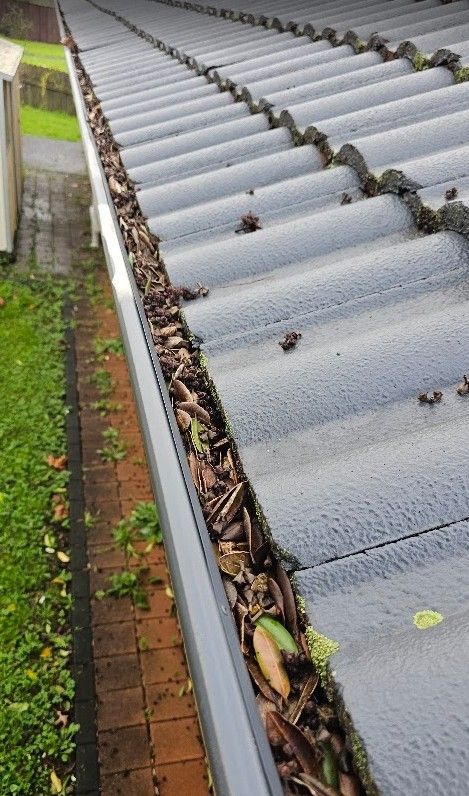 Overflowing gutter blocked with leaves on an Auckland home in winter