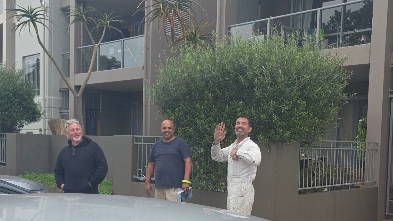 Group of men standing outside an apartment building