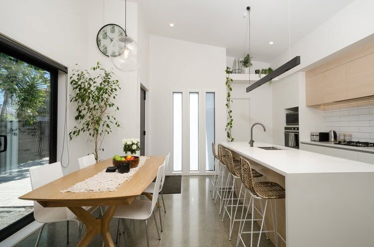 Beautiful kitchen with white bench top and timber table
