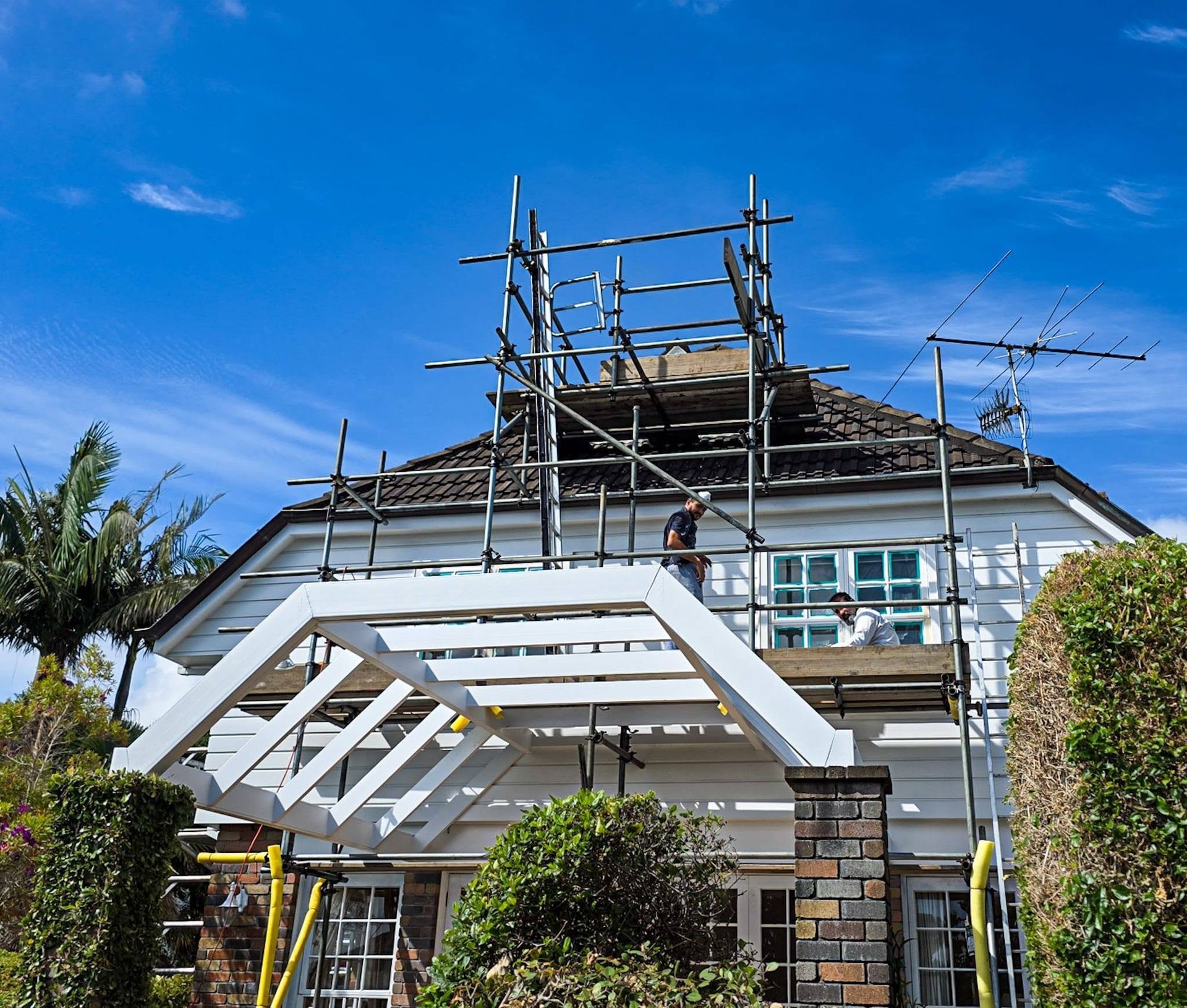 Roof scaffolding silhouetted against a blue sky