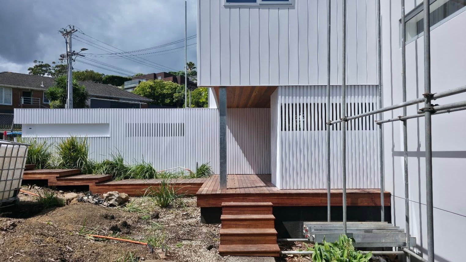 Modern building exterior with vertical timber slat cladding and deck stairs