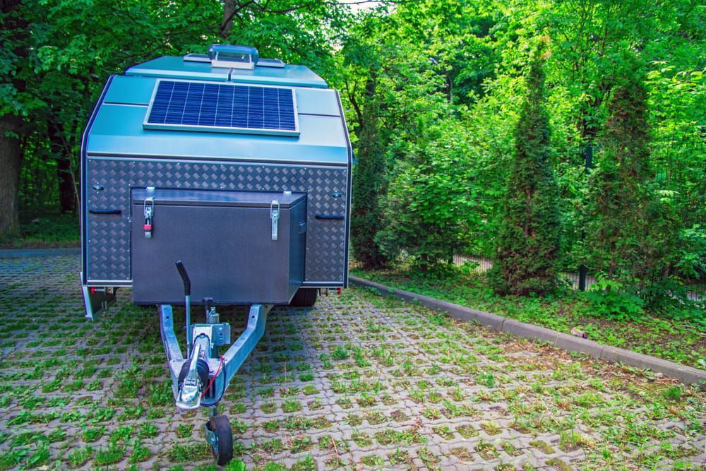 A Trailer With a Solar Panel on Top of It is Parked in a Parking Lot — Auto Electrical Solutions In Pialba, QLD