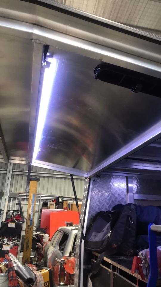 A Light is Hanging From the Ceiling of a Van in a Garage — Auto Electrical Solutions In Pialba, QLD