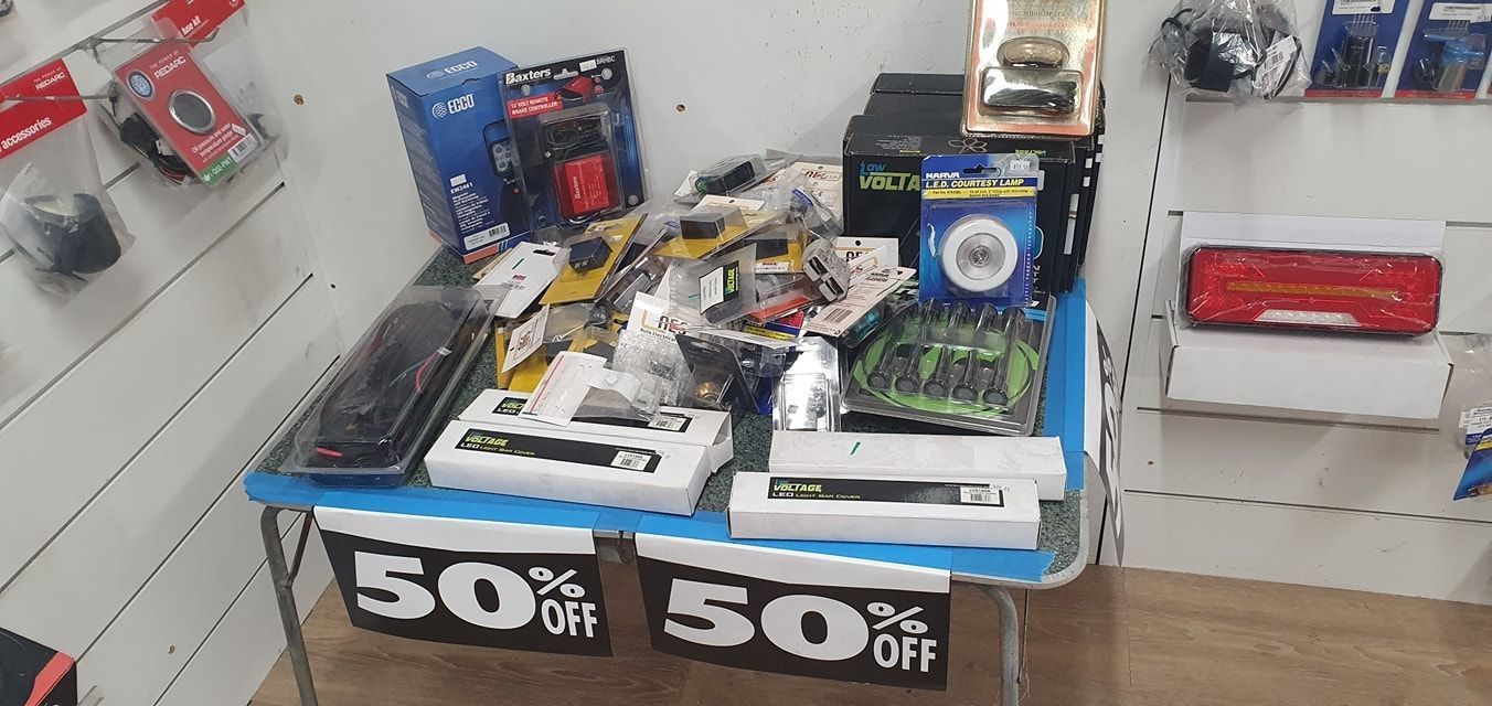 A Table With a Lot of Items on It and a Sign That Says 50% Off — Auto Electrical Solutions In Pialba, QLD