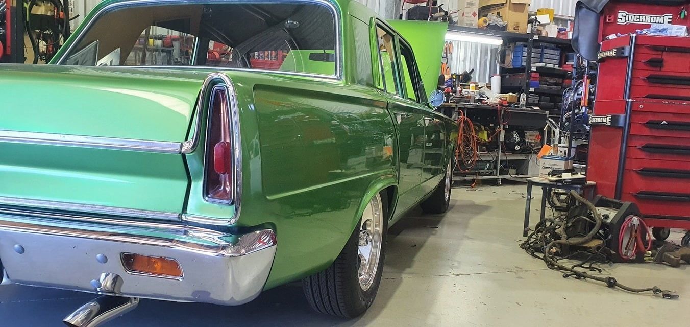 A Green Car Is Parked In A Garage Next To A Red Toolbox — Auto Electrical Solutions In Pialba, QLD