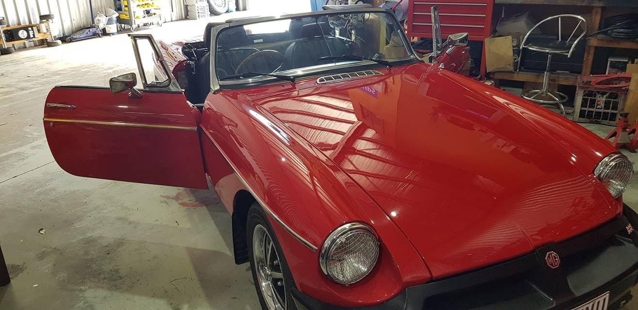 A Red Sports Car Is Parked In A Garage With Its Doors Open — Auto Electrical Solutions In Pialba, QLD
