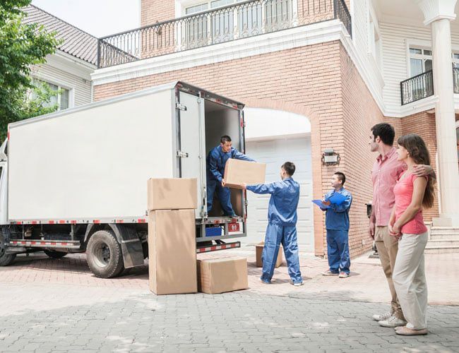 family watching a moving team unpack their boxes family watching a moving team unpack their boxes