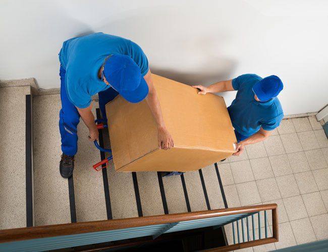 team moving a box up a flight of stairs team moving a box up a flight of stairs