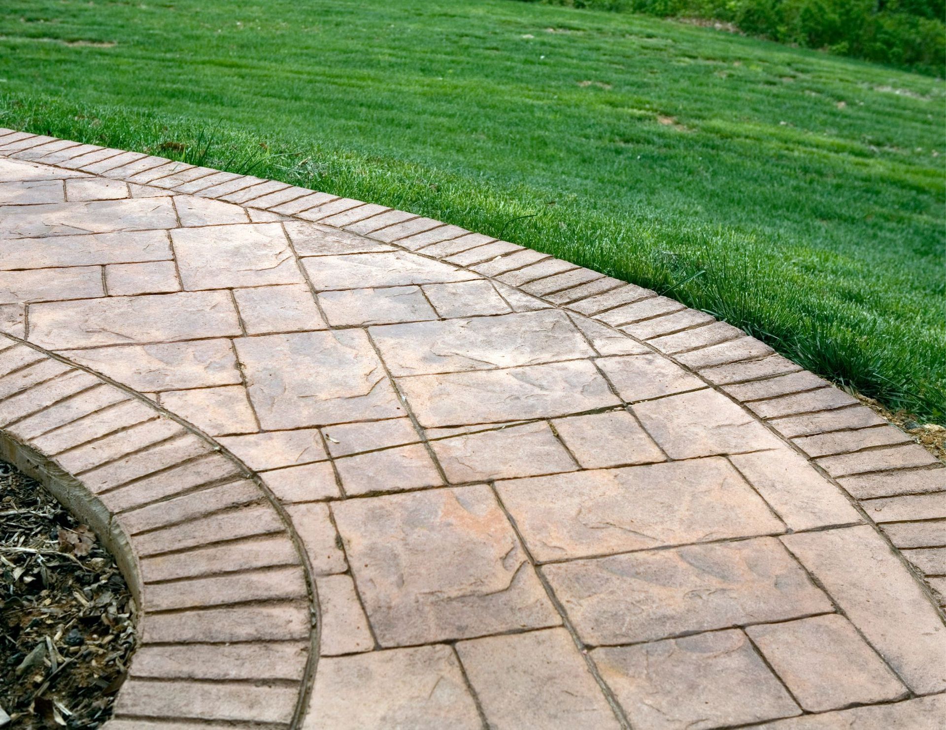 stamped concrete walkway in ottawa near a green lawn