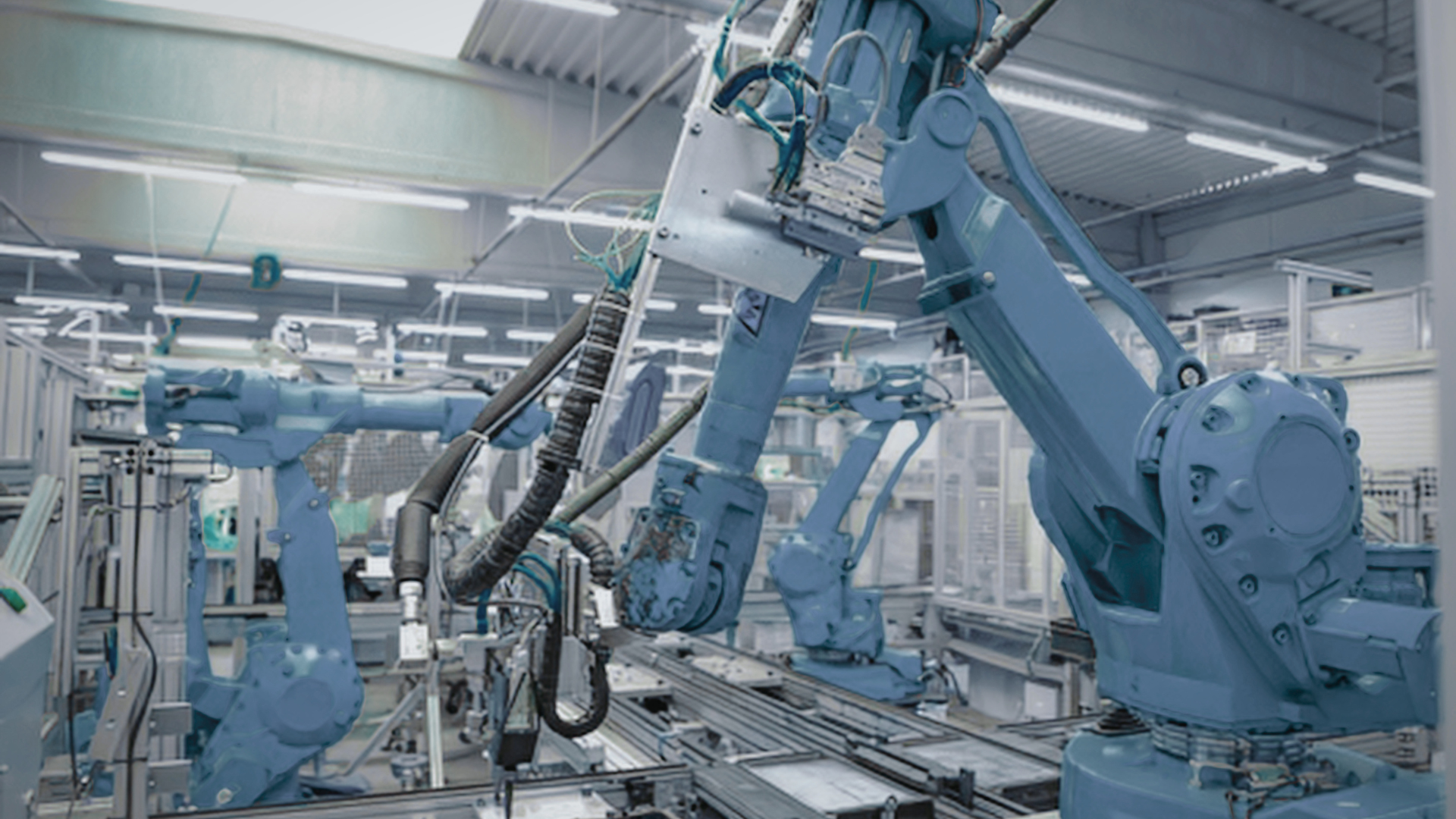 Industrial robot arms operating on an assembly line in a bright factory workshop