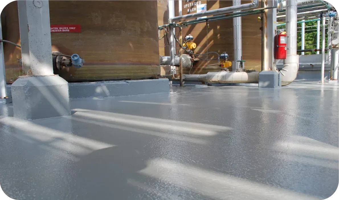 Low-angle view of an industrial floor with metal pipes and equipment in a factory setting