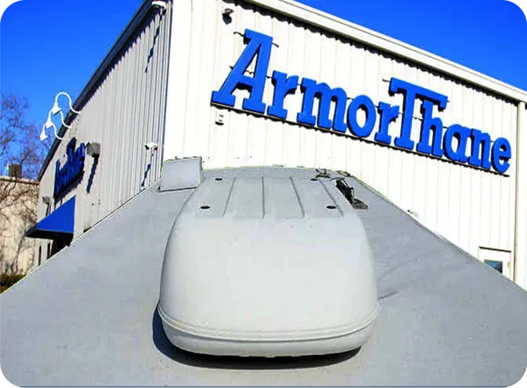 ArmorThane building with a rooftop sign and a white vehicle in the foreground