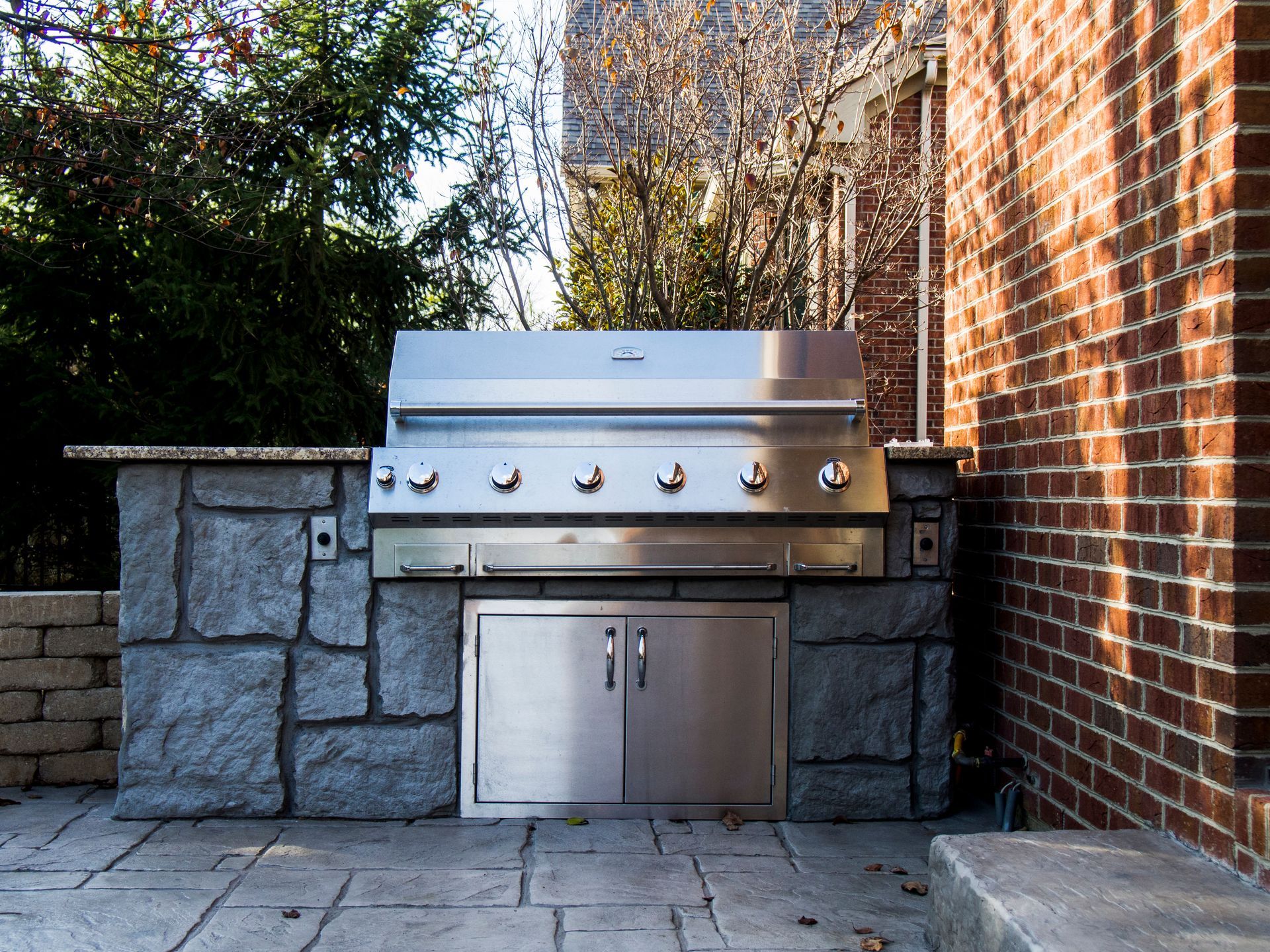 Custom BBQ grill installation with stainless grill in stone island.