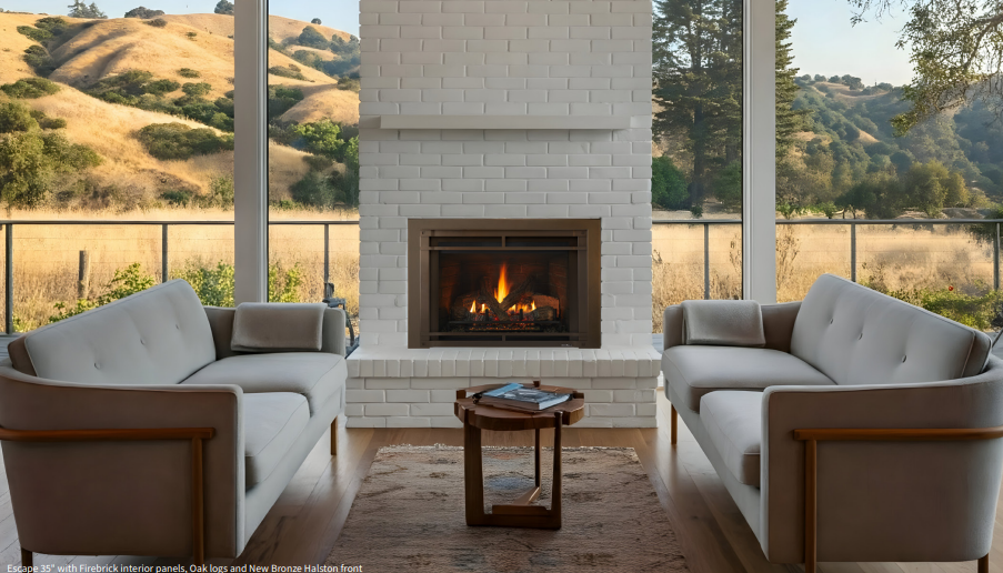 Heat & Glo Escape Cozy living room with a lit fireplace, two beige sofas, and hills visible through large windows