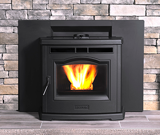 Harman P-Series Black wood stove with bright orange flame in a stone fireplace hearth