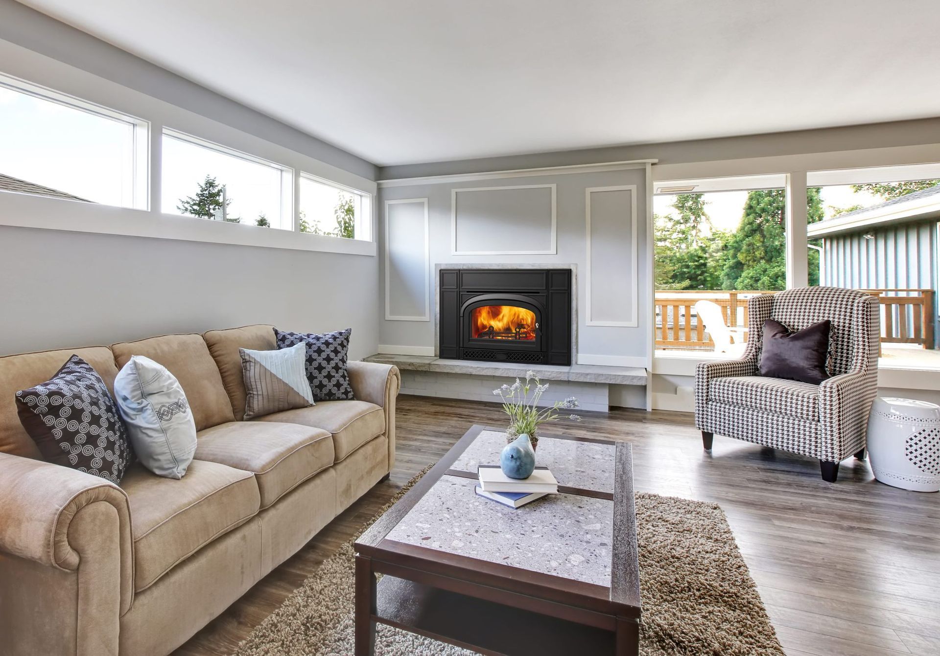 Cozy living room with a fireplace, sofa, patterned chair, and a coffee table. Cozy living room with a fireplace, sofa, patterned chair, and a coffee table.