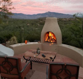 An outdoor fireplace made with paving stone with wood burning.
