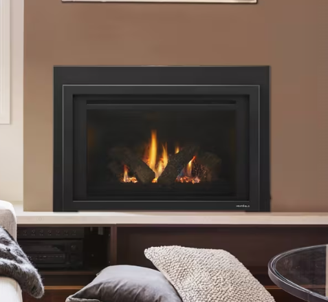 Heat & Glo Provident Modern living room fireplace with a black frame and visible flames, framed by beige walls and pillows in the foreground