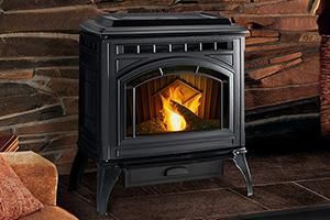 Black pellet stove with burning fire, set in front of a stone wall, with a small drawer at the bottom. Black pellet stove with burning fire, set in front of a stone wall, with a small drawer at the bottom.
