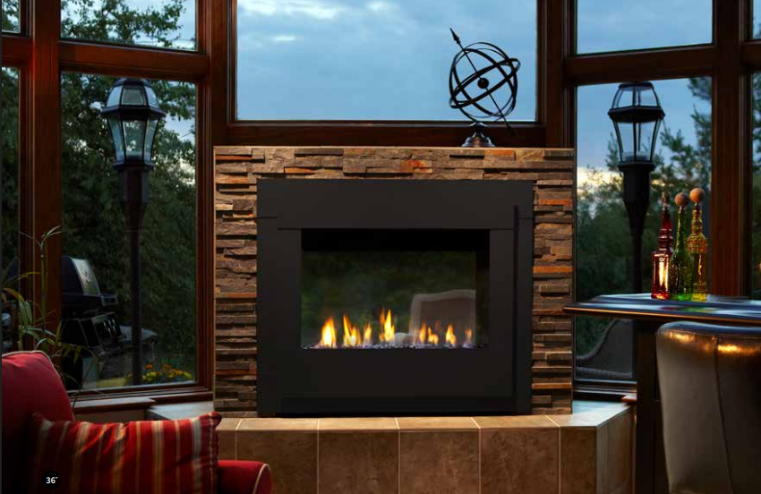 Image Placeholder Cozy modern fireplace framed by large windows, with stone surround and warm firelit seating area