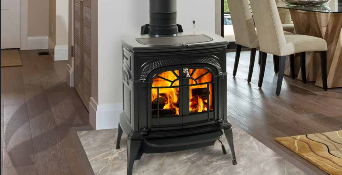 Vermont Castings Intrepid Black wood stove burning in a home with a dining area nearby
