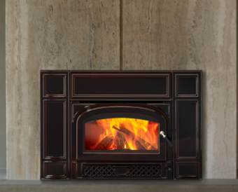 Vermont Castings Gifford Black fireplace insert with bright flames set into a gray stone wall.