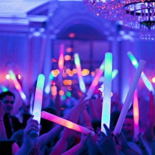 A crowd of people holding glow sticks in their hands