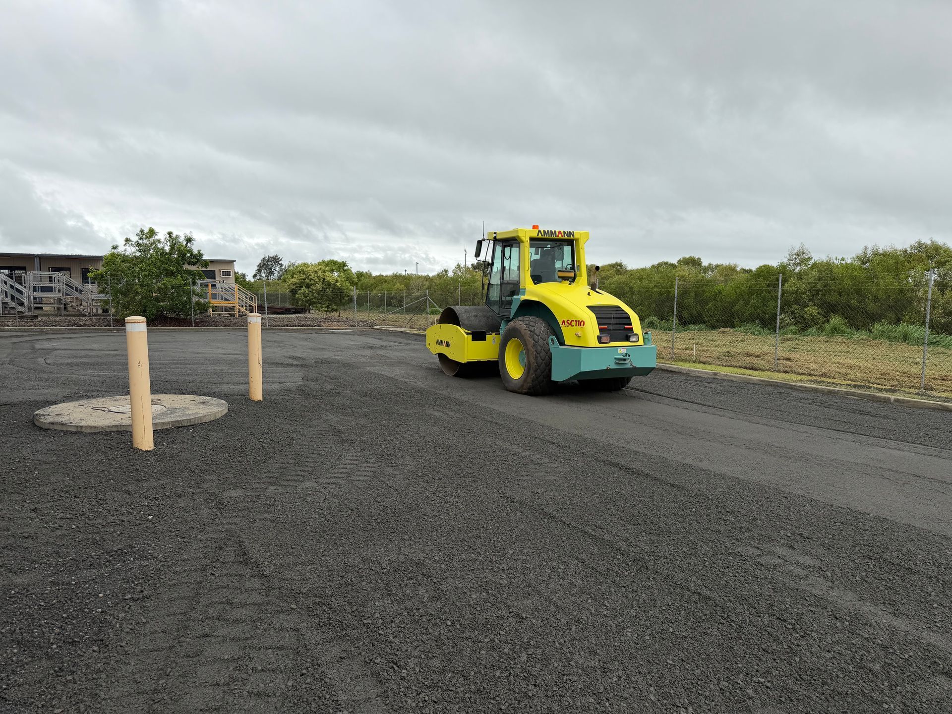 Yellow Road Roller On A Dark Gravel Lot Under Cloudy Sky — Blue Dog Hire Qld In Midge Point, QLD