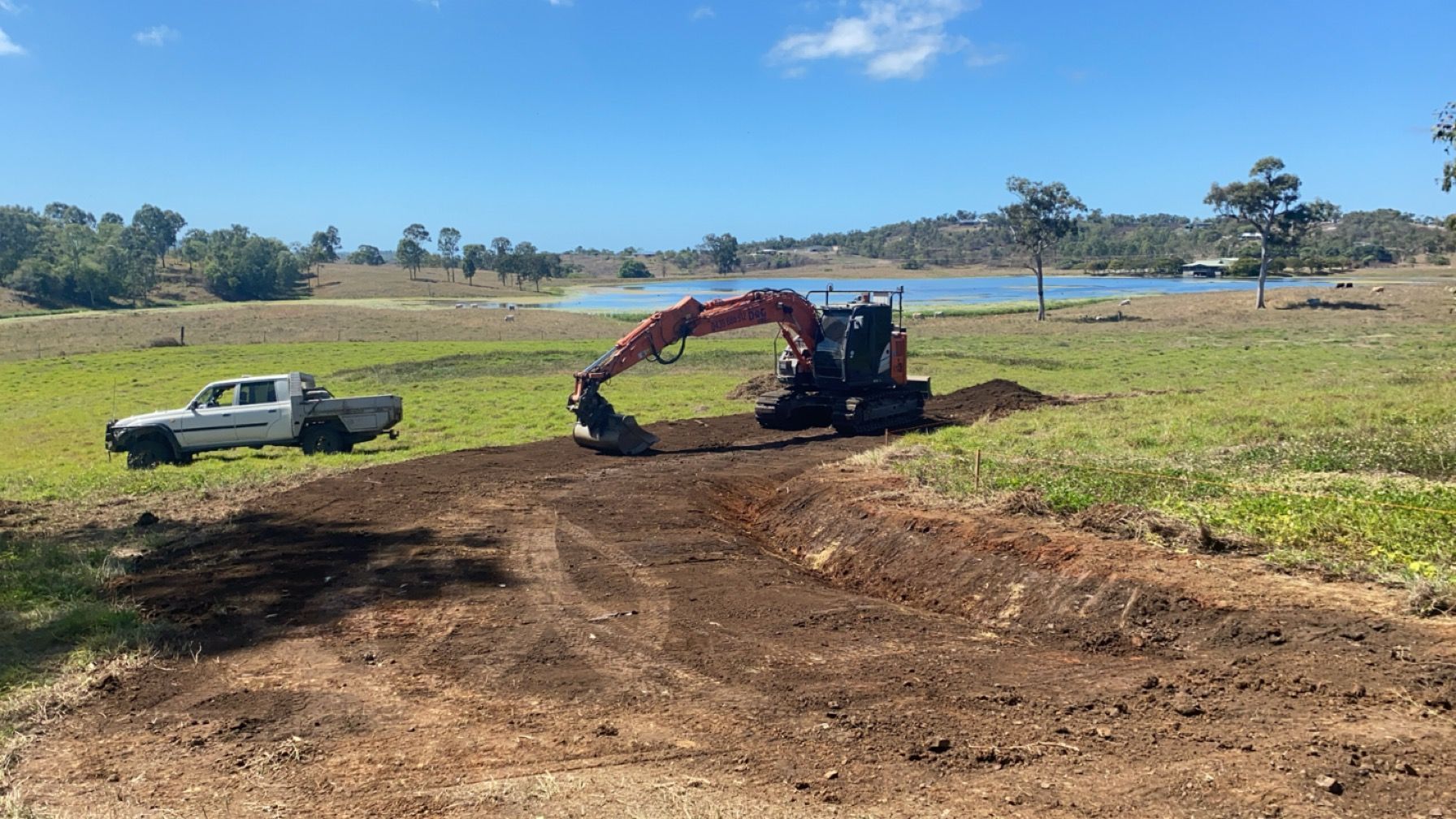 Excavator Working On Dirt Near A White Pickup — Blue Dog Hire Qld In Midge Point, QLD