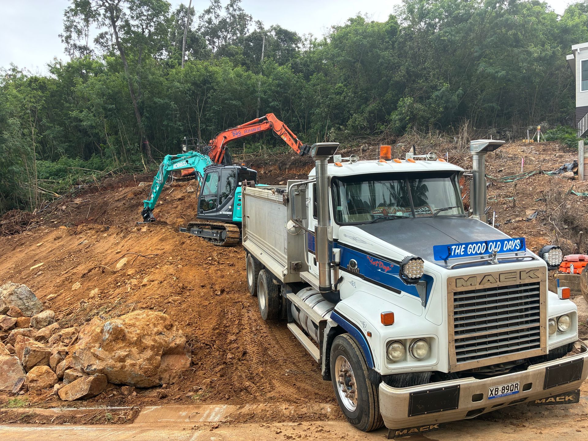 White Dump Truck And Excavator At A Muddy Construction Site — Blue Dog Hire Qld In Airlie Beach, QLD