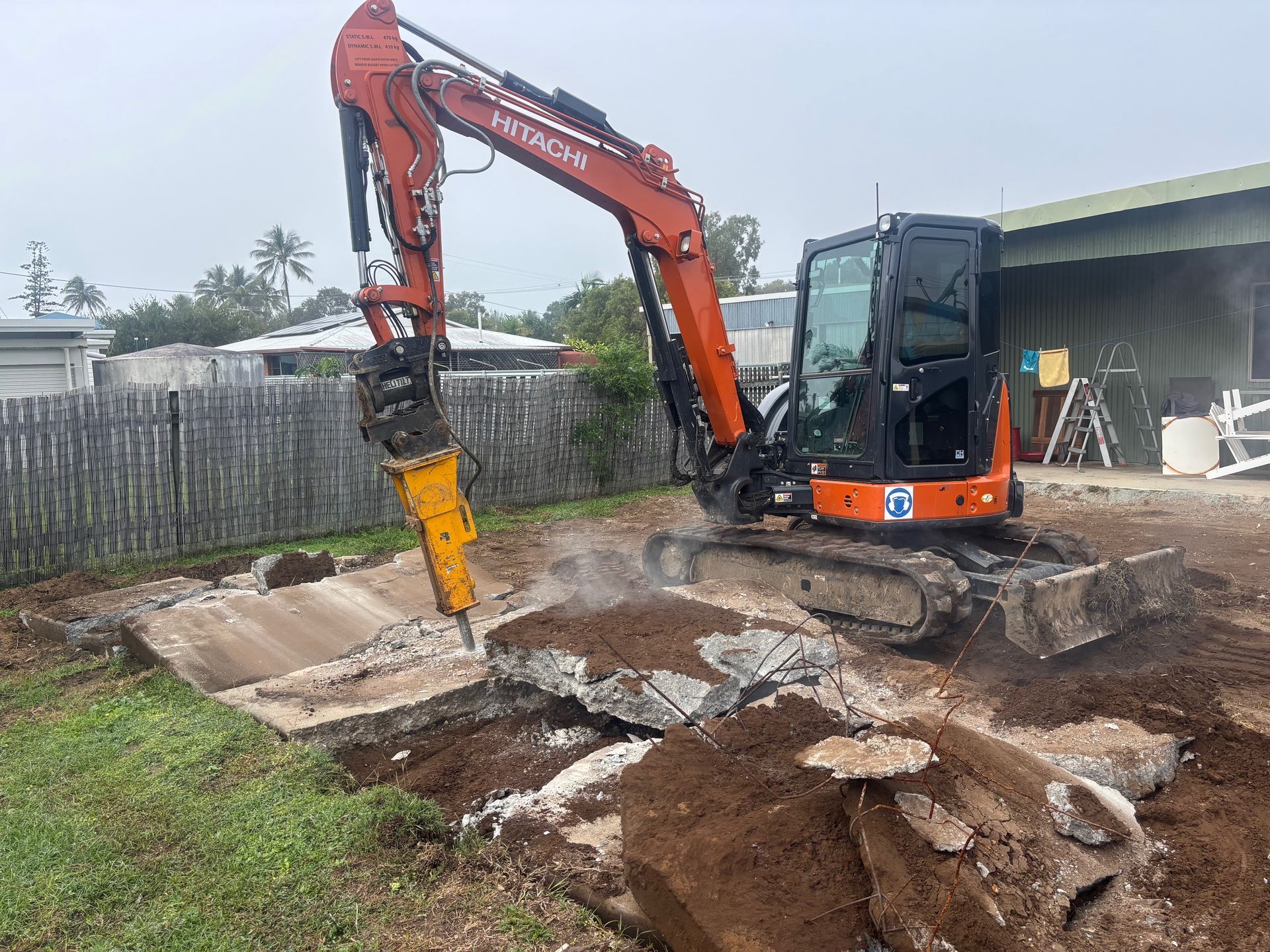 A Large Yellow Excavator Is Sitting On Top Of A Dirt Field — Blue Dog Hire Qld In Cannonvale, QLD